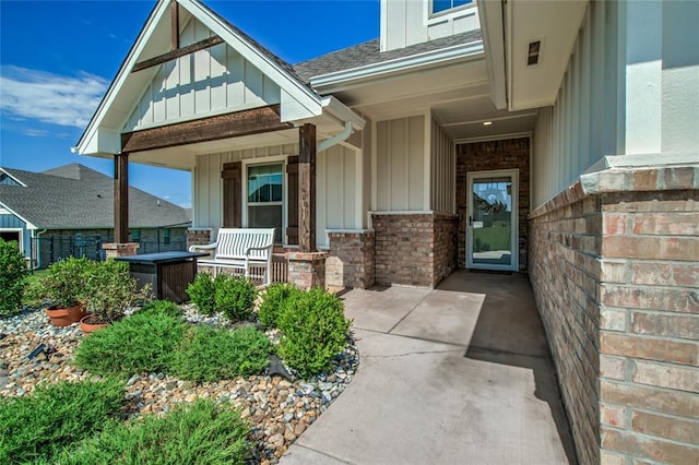 13420 Saltgrass Dr, Edmond, OK 73025 - doorway to property with board and batten siding, a porch, brick siding, and a shingled roof