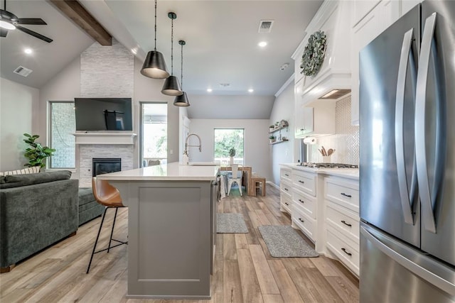13420 Saltgrass Dr, Edmond, OK 73025 - kitchen featuring stainless steel appliances, light countertops, a breakfast bar area, open floor plan, and an island with sink