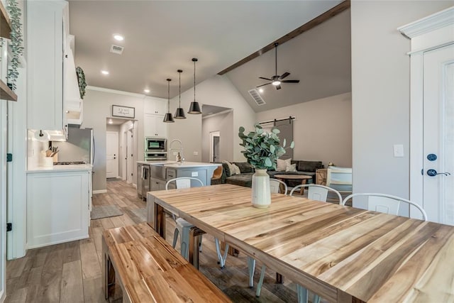 13420 Saltgrass Dr, Edmond, OK 73025 - dining area featuring light wood-style flooring, a ceiling fan, recessed lighting, ornamental molding, and high vaulted ceiling