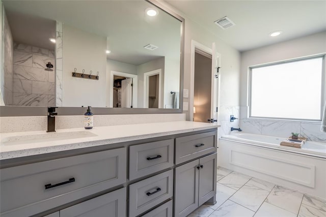 13420 Saltgrass Dr, Edmond, OK 73025 - full bath featuring marble look tile flooring, a garden tub, vanity, recessed lighting, and a walk in closet
