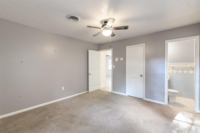 304 S 4th St, Noble, OK 73068 - unfurnished bedroom featuring carpet, ensuite bath, a textured ceiling, and ceiling fan