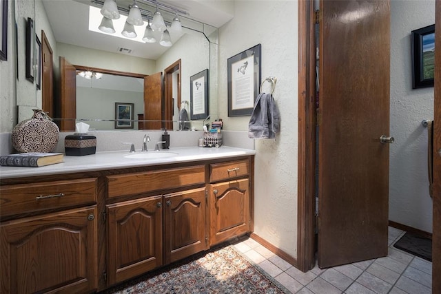 2205 SE 90th St, Lawton, OK 73501 - bathroom featuring a textured wall, tile patterned floors, and vanity