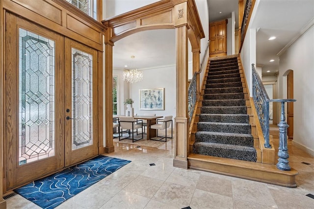 4609 Flint Ridge Dr, Norman, OK 73072 - entryway featuring arched walkways, stairs, crown molding, a chandelier, and french doors