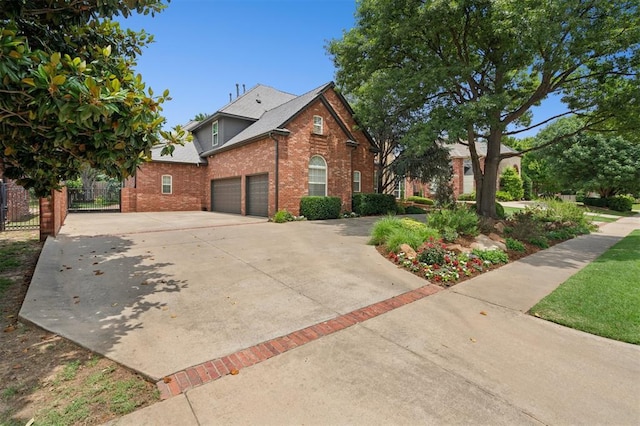 4609 Flint Ridge Dr, Norman, OK 73072 - view of home's exterior featuring brick siding, driveway, an attached garage, and a shingled roof