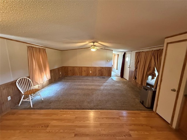 339133 E 870th Rd, Chandler, OK 74834 - unfurnished room with a ceiling fan, a wainscoted wall, wooden walls, a textured ceiling, and wood finished floors