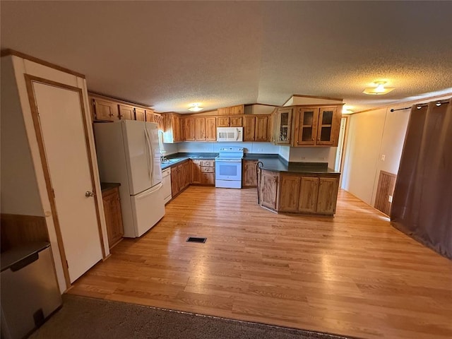 339133 E 870th Rd, Chandler, OK 74834 - kitchen with white appliances, dark countertops, brown cabinets, light wood-style floors, and glass insert cabinets