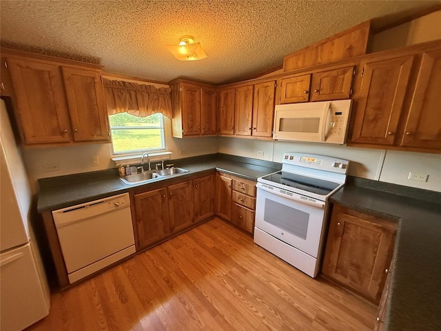 339133 E 870th Rd, Chandler, OK 74834 - kitchen with white appliances, dark countertops, brown cabinetry, light wood finished floors, and a textured ceiling