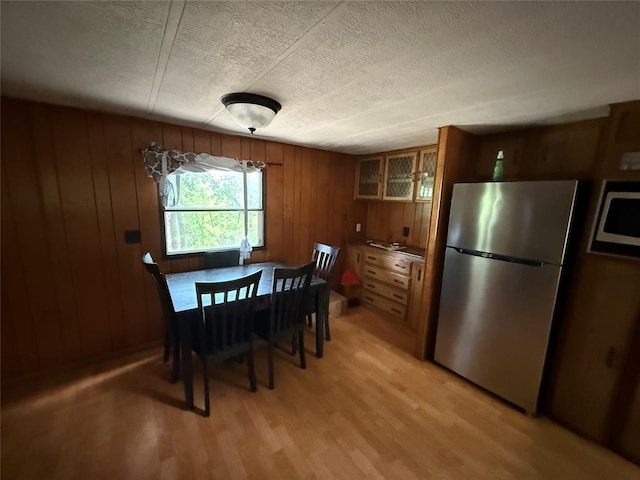 120347 S 4186th Rd, Eufaula, OK 74432 - dining room featuring a textured ceiling, light wood-style flooring, and wood walls