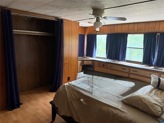 120347 S 4186th Rd, Eufaula, OK 74432 - bedroom with light wood-style floors, a closet, wood walls, and ceiling fan