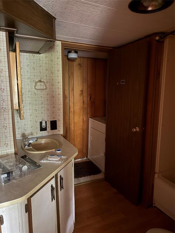 120347 S 4186th Rd, Eufaula, OK 74432 - bathroom with washer / dryer, vanity, wood finished floors, and a textured ceiling