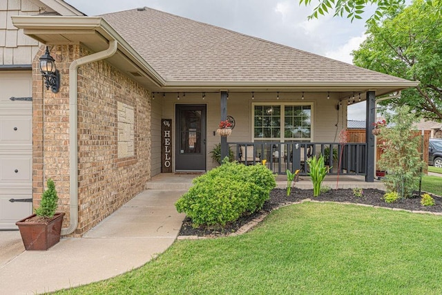 2432 NW 175th St, Edmond, OK 73012 - view of exterior entry featuring a shingled roof, a porch, a yard, and brick siding