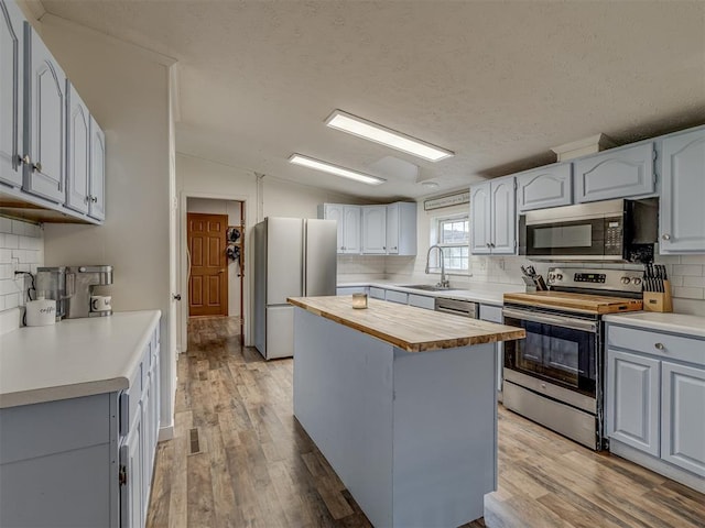 7401 E Forrest Hills Rd, Guthrie, OK 73044 - kitchen featuring stainless steel appliances, butcher block countertops, decorative backsplash, light wood finished floors, and lofted ceiling