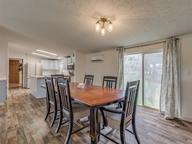 7401 E Forrest Hills Rd, Guthrie, OK 73044 - dining area featuring an AC wall unit, light wood finished floors, and a textured ceiling