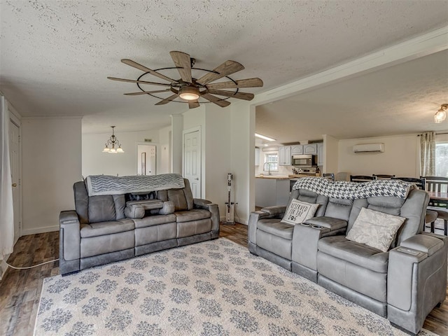 7401 E Forrest Hills Rd, Guthrie, OK 73044 - living area with a wall unit AC, a textured ceiling, a chandelier, ceiling fan, and wood finished floors