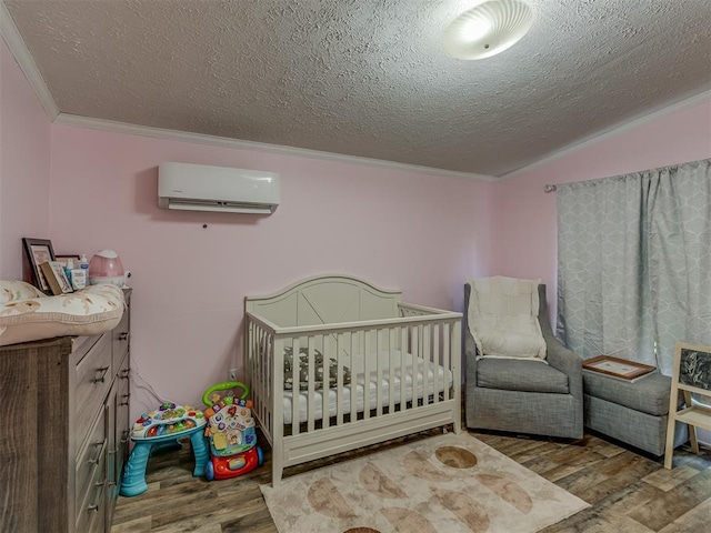 7401 E Forrest Hills Rd, Guthrie, OK 73044 - bedroom featuring an AC wall unit, wood finished floors, ornamental molding, a textured ceiling, and a crib