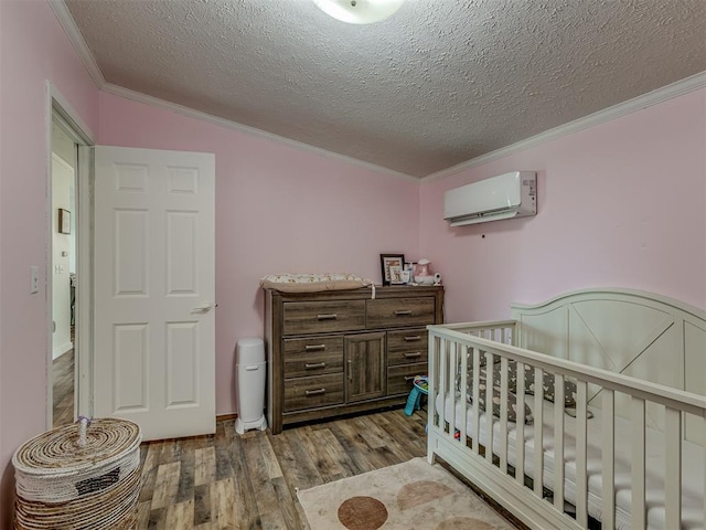 7401 E Forrest Hills Rd, Guthrie, OK 73044 - bedroom featuring crown molding, an AC wall unit, wood finished floors, a textured ceiling, and a crib