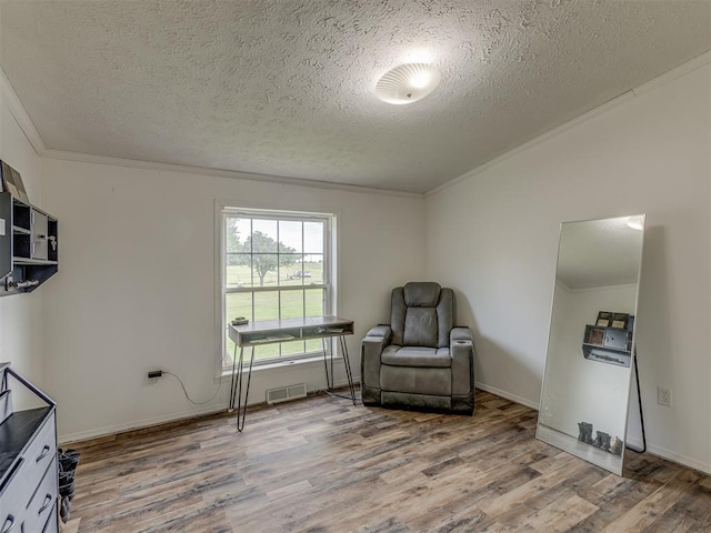 7401 E Forrest Hills Rd, Guthrie, OK 73044 - sitting room with wood finished floors, a textured ceiling, and crown molding