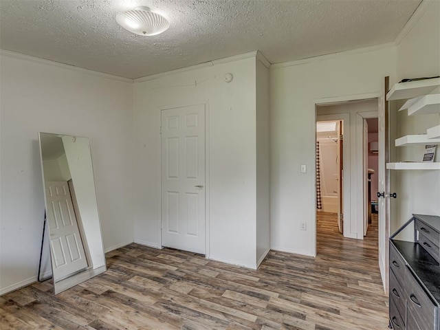 7401 E Forrest Hills Rd, Guthrie, OK 73044 - unfurnished bedroom featuring wood finished floors, a textured ceiling, and ornamental molding