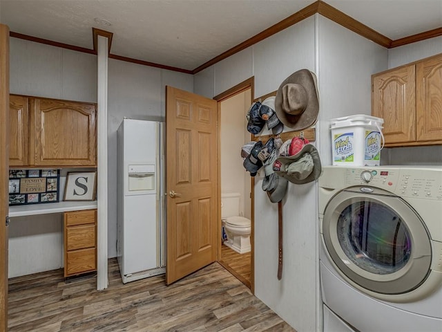 7401 E Forrest Hills Rd, Guthrie, OK 73044 - washroom featuring washer / dryer, cabinet space, light wood finished floors, and crown molding