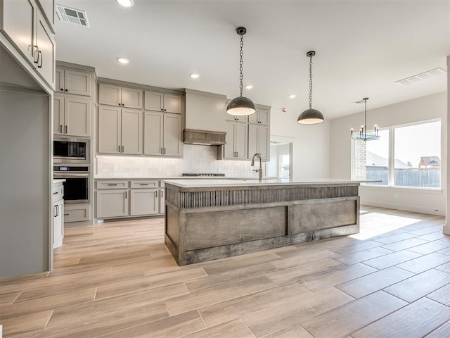 1136 Jozie Way, Tuttle, OK 73089 - kitchen with appliances with stainless steel finishes, gray cabinets, backsplash, a chandelier, and recessed lighting