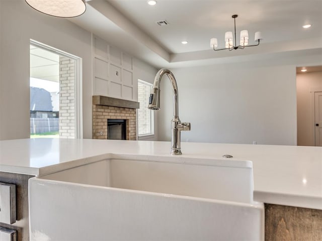 1136 Jozie Way, Tuttle, OK 73089 - kitchen featuring a chandelier, a fireplace, recessed lighting, a tray ceiling, and pendant lighting