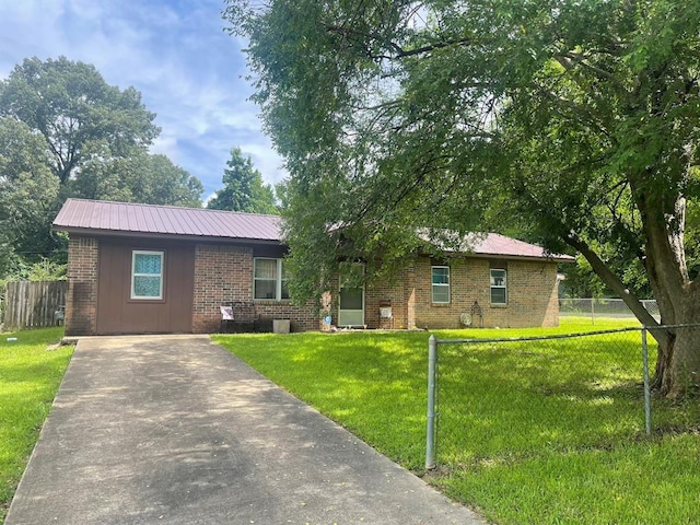 1003 Lukfata St, Broken Bow, OK 74728 - ranch-style house with brick siding, concrete driveway, and a metal roof