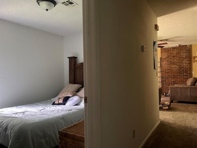 1003 Lukfata St, Broken Bow, OK 74728 - carpeted bedroom featuring a textured ceiling and brick wall