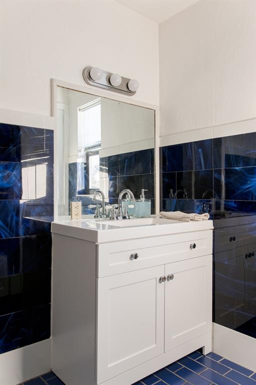 2720 NW 26th St, Oklahoma City, OK 73107 - full bathroom featuring vanity, tile patterned flooring, and tile walls