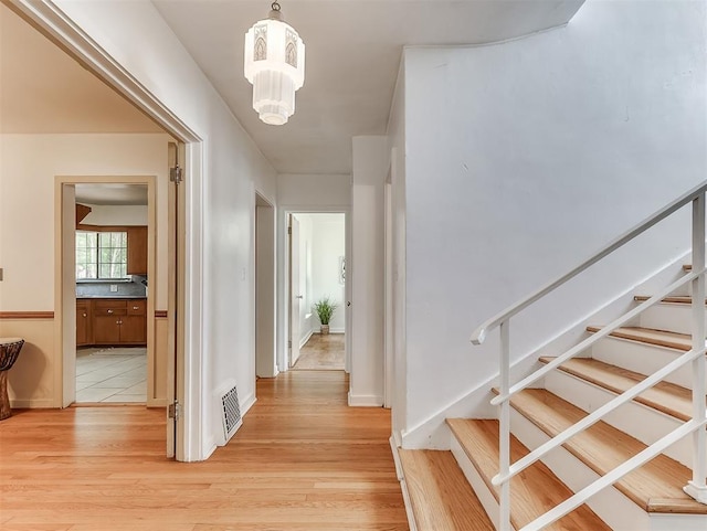 2720 NW 26th St, Oklahoma City, OK 73107 - hallway with stairway, light wood-style flooring, and a chandelier