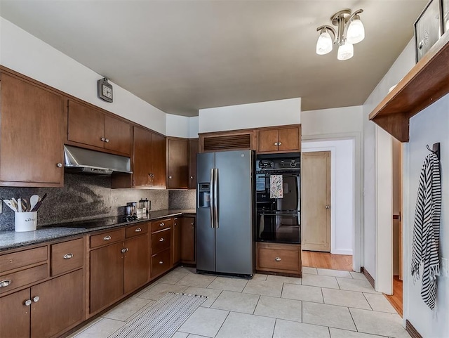2720 NW 26th St, Oklahoma City, OK 73107 - kitchen featuring black appliances, under cabinet range hood, dark countertops, and tasteful backsplash
