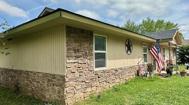 909 N Center St, Shawnee, OK 74801 - view of side of home with stone siding, a lawn, and roof with shingles