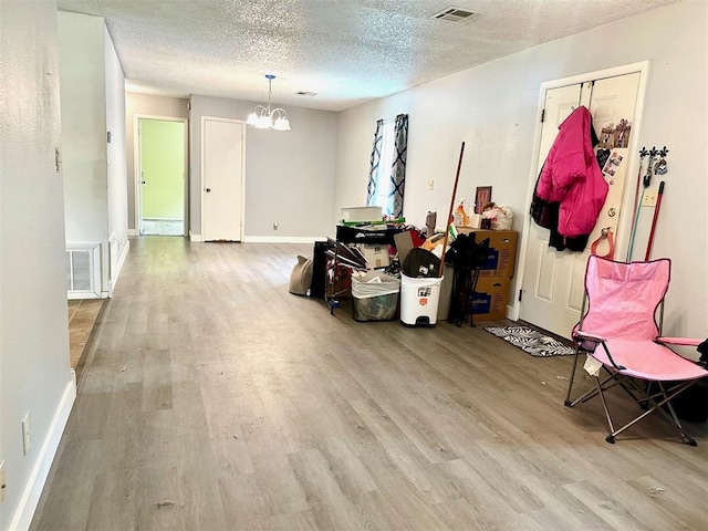 909 N Center St, Shawnee, OK 74801 - empty room with wood finished floors, a chandelier, and a textured ceiling