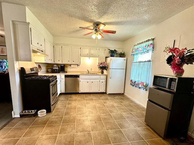 909 N Center St, Shawnee, OK 74801 - kitchen featuring stainless steel appliances, under cabinet range hood, a ceiling fan, white cabinetry, and a textured ceiling