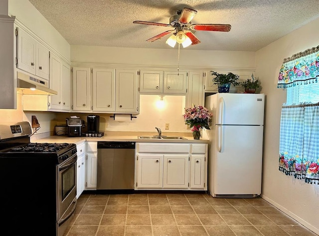 909 N Center St, Shawnee, OK 74801 - kitchen with appliances with stainless steel finishes, under cabinet range hood, a ceiling fan, light countertops, and a textured ceiling