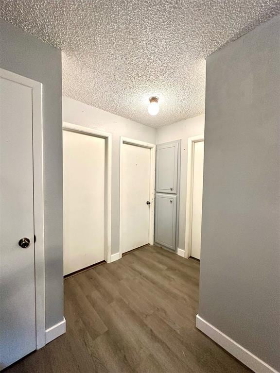 909 N Center St, Shawnee, OK 74801 - unfurnished bedroom featuring wood finished floors, a textured ceiling, and multiple closets