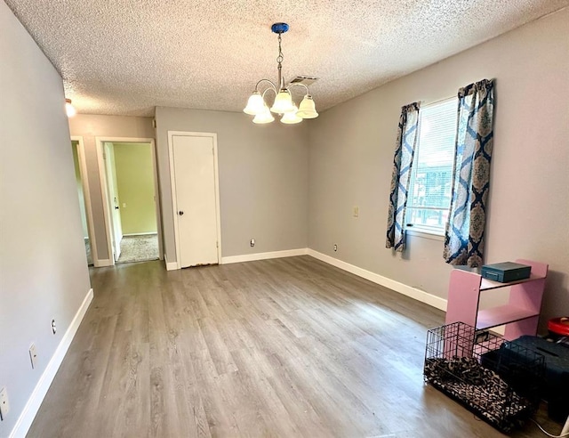 909 N Center St, Shawnee, OK 74801 - spare room featuring a chandelier, a textured ceiling, and wood finished floors