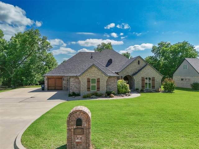 2309 Pinehurst Ct, Shawnee, OK 74801 - french country home featuring concrete driveway, an attached garage, stone siding, and a front yard