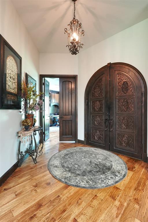 2309 Pinehurst Ct, Shawnee, OK 74801 - entryway featuring arched walkways, a chandelier, and wood finished floors