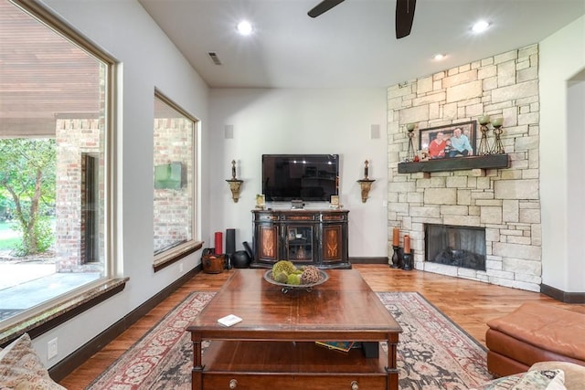 2309 Pinehurst Ct, Shawnee, OK 74801 - living area with healthy amount of natural light, a ceiling fan, wood finished floors, a stone fireplace, and recessed lighting