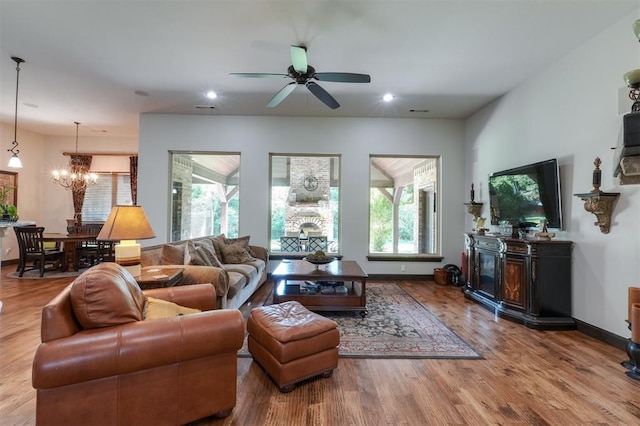 2309 Pinehurst Ct, Shawnee, OK 74801 - living room with a fireplace, a chandelier, wood finished floors, a ceiling fan, and recessed lighting
