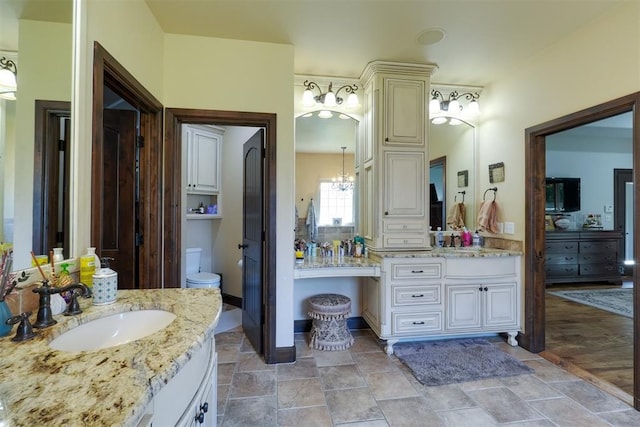 2309 Pinehurst Ct, Shawnee, OK 74801 - full bathroom with two vanities, stone finish flooring, and a chandelier