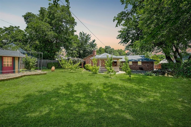 1825 Kings Rd, Edmond, OK 73013 - yard at dusk featuring covered porch
