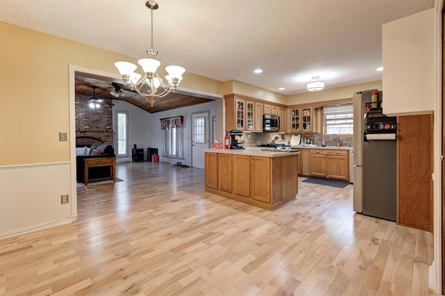 1825 Kings Rd, Edmond, OK 73013 - kitchen with stainless steel appliances, light wood-style floors, open floor plan, lofted ceiling, and a chandelier