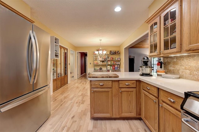 1825 Kings Rd, Edmond, OK 73013 - kitchen featuring freestanding refrigerator, a peninsula, light countertops, backsplash, and recessed lighting
