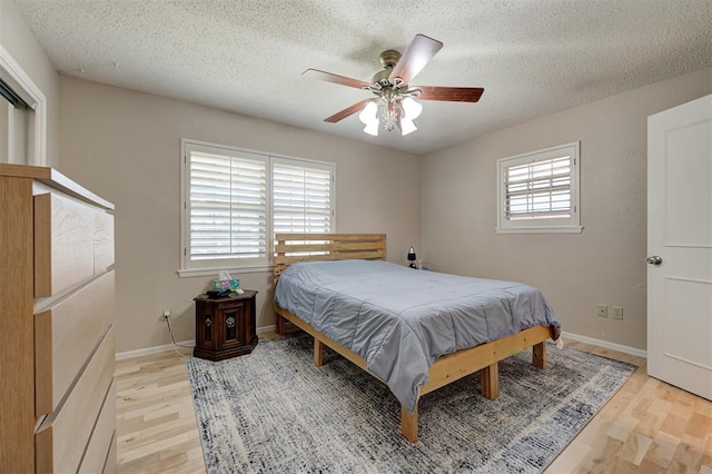 1825 Kings Rd, Edmond, OK 73013 - bedroom with light wood-style flooring, a textured ceiling, and a ceiling fan