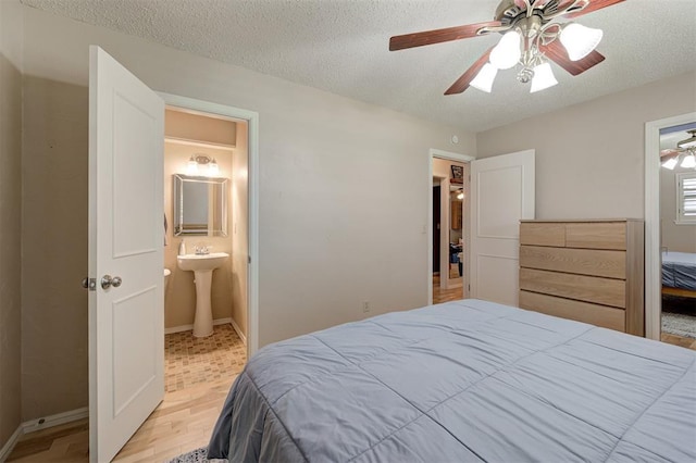 1825 Kings Rd, Edmond, OK 73013 - bedroom featuring a textured ceiling, light wood-type flooring, ensuite bathroom, and ceiling fan