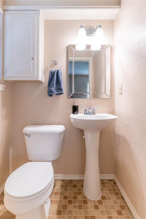 1825 Kings Rd, Edmond, OK 73013 - half bath featuring toilet and baseboards