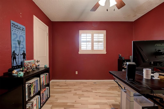 1825 Kings Rd, Edmond, OK 73013 - home office with ceiling fan, light wood-style flooring, and a textured ceiling
