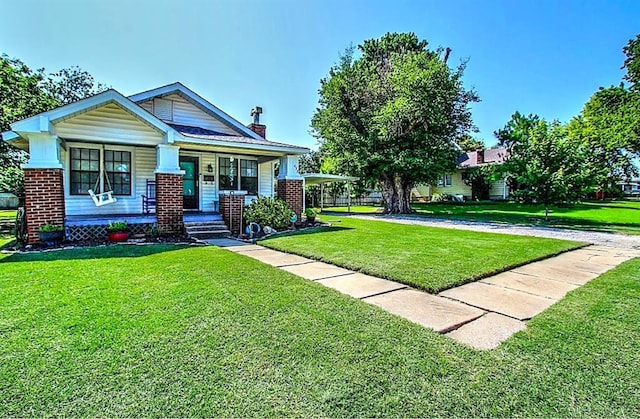 432 S 6th St, Yukon, OK 73099 - view of front of home with a front yard, covered porch, a chimney, and brick siding