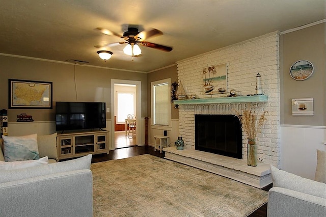 432 S 6th St, Yukon, OK 73099 - living room with wood finished floors, a ceiling fan, wainscoting, a brick fireplace, and ornamental molding